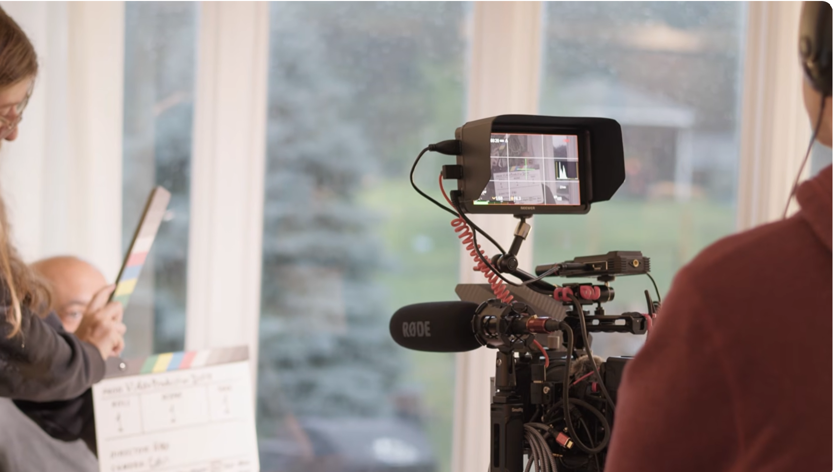 A cinema camera and boom microphone framed on an interview subject