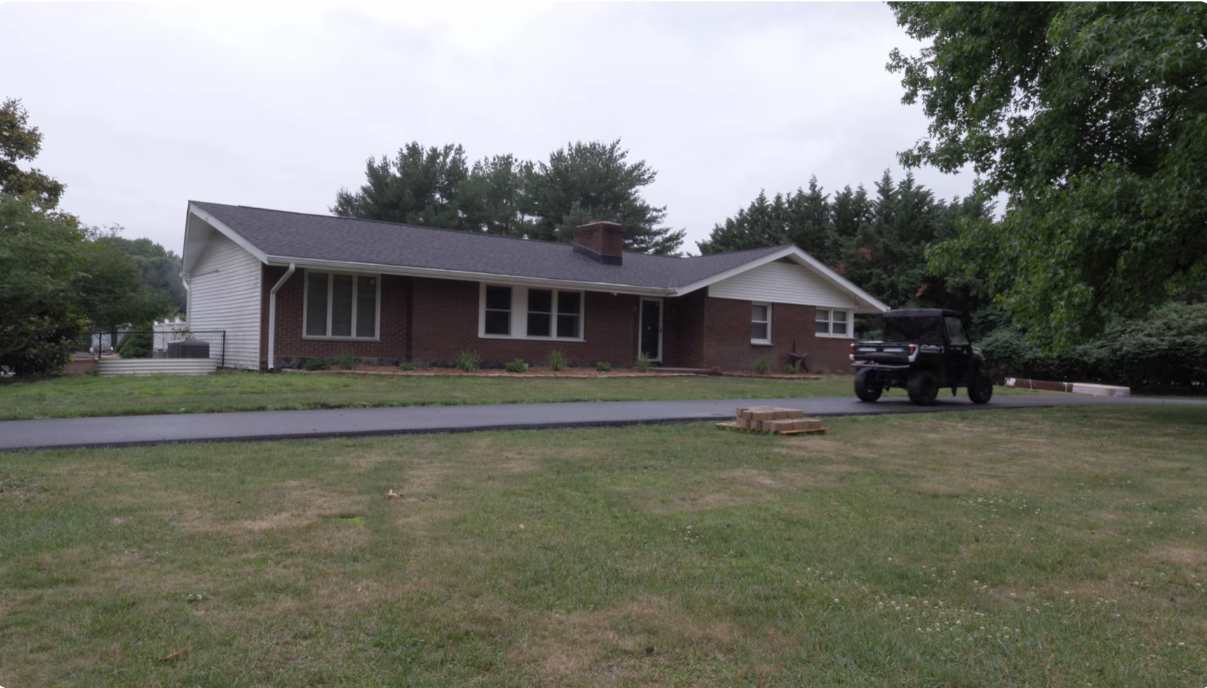 The brick farmhouse and drive at the center of the property on an overcast morning